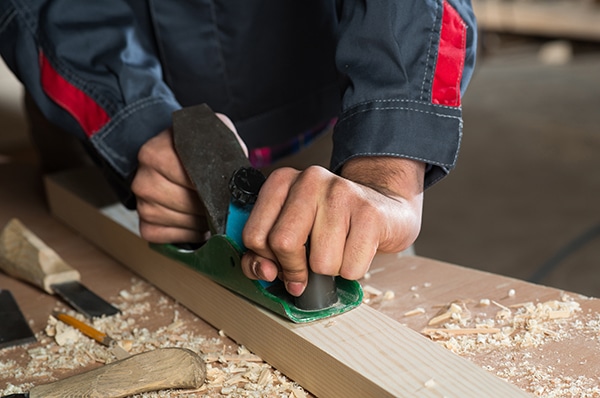 Close up of carpenter's hands working with the jointer