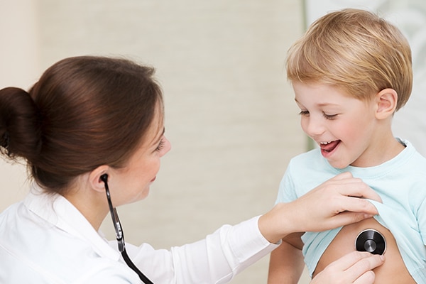 Cute little boy with pleasure visiting pediatrician, scheduled checkup of a baby health, appointment with the family doctor, healthy lifestyle